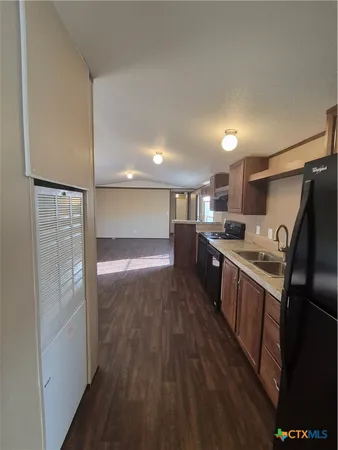 a kitchen with stainless steel appliances granite countertop a refrigerator a sink and a stove