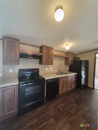 a kitchen with stainless steel appliances granite countertop a sink and a stove