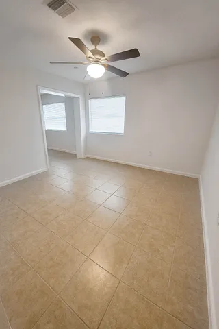 an empty room with windows and fan