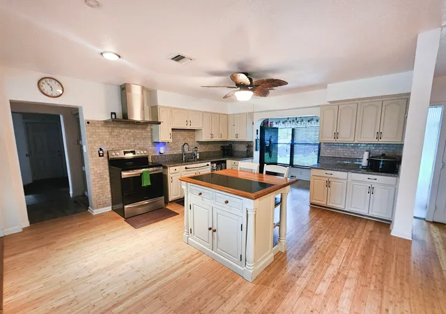 a kitchen with stainless steel appliances granite countertop a stove a sink dishwasher and a refrigerator