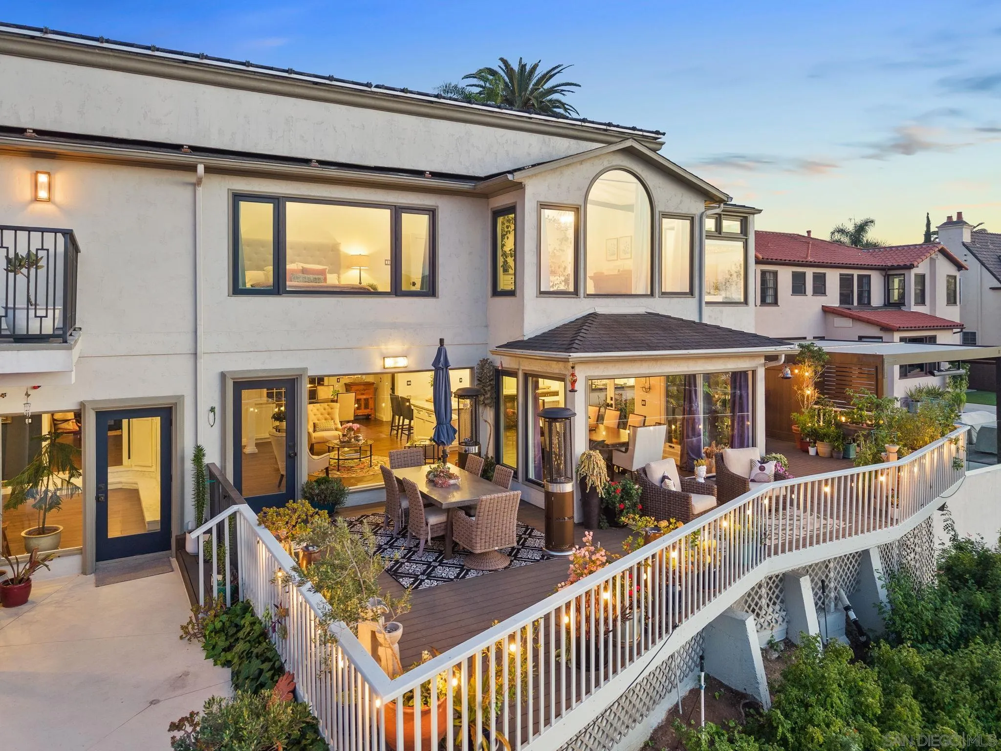 4136 Palisades Road San Diego, CA 92116 - Photo 59 of 68 a view of a brick house with large windows and a table and chairs