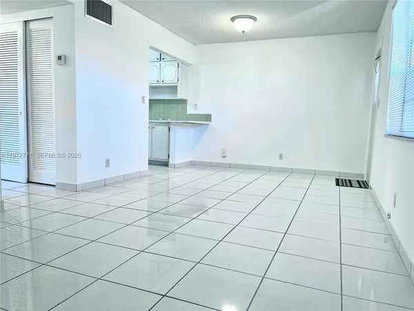 a view of a livingroom with an empty space and a window