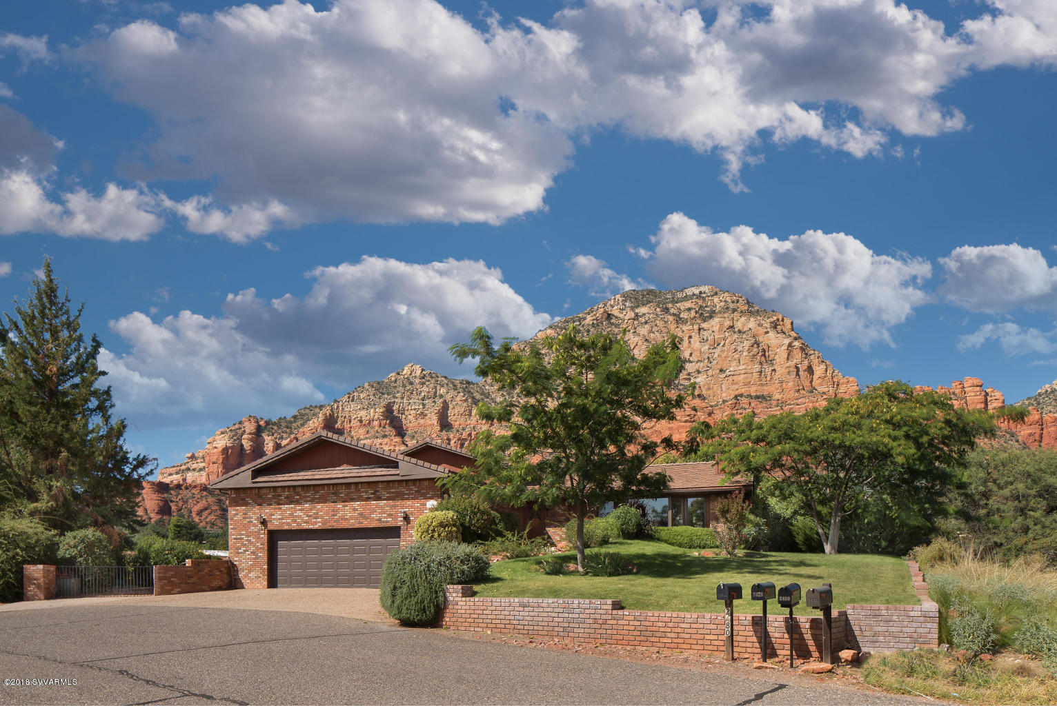 2450 Homestead Road Sedona, AZ 86336 - Photo 3 of 25 a front view of a house with a yard and garden