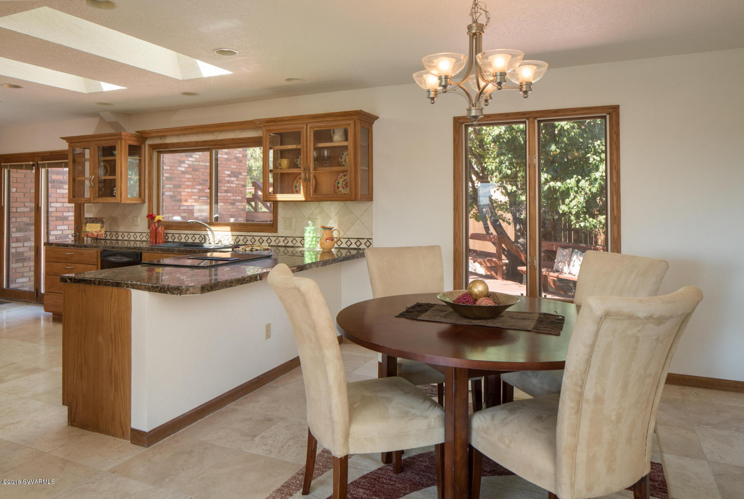 2450 Homestead Road Sedona, AZ 86336 - Photo 8 of 25 a dining room with wooden floor a chandelier a wooden table and chairs