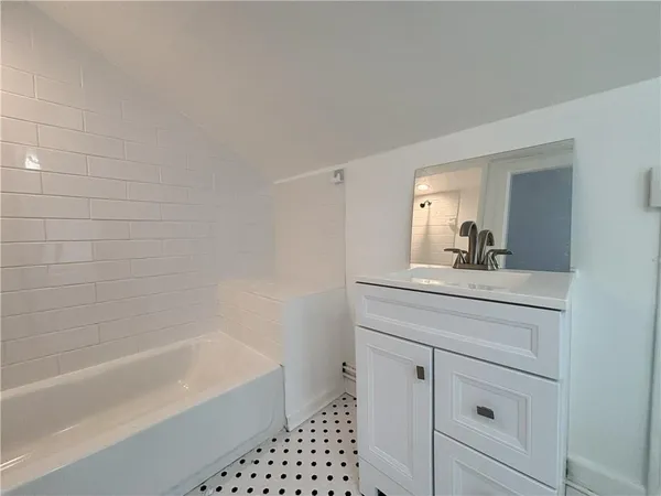 a bathroom with a bathtub a sink a vanity and a shower