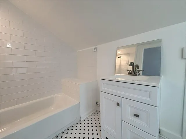 a bathroom with a bathtub a sink a vanity and a shower