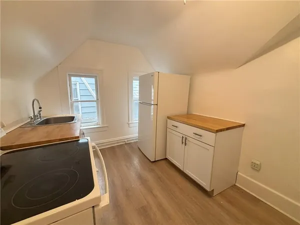 a kitchen with granite countertop a sink stove and refrigerator
