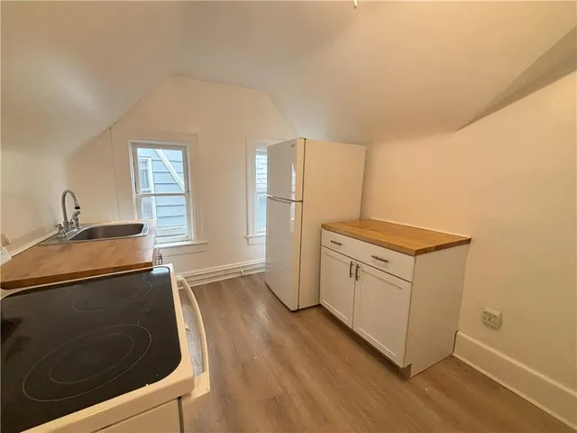 a kitchen with granite countertop a sink stove and refrigerator