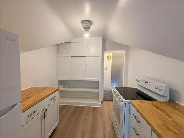 a kitchen that has a microwave a stove and a refrigerator
