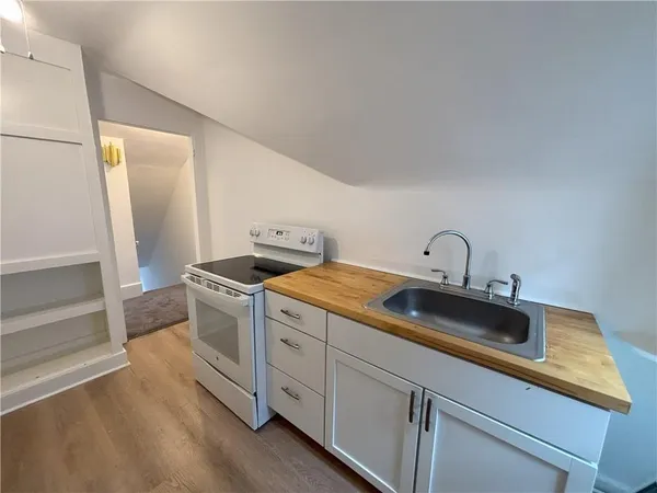 a kitchen with sink stove and cabinets