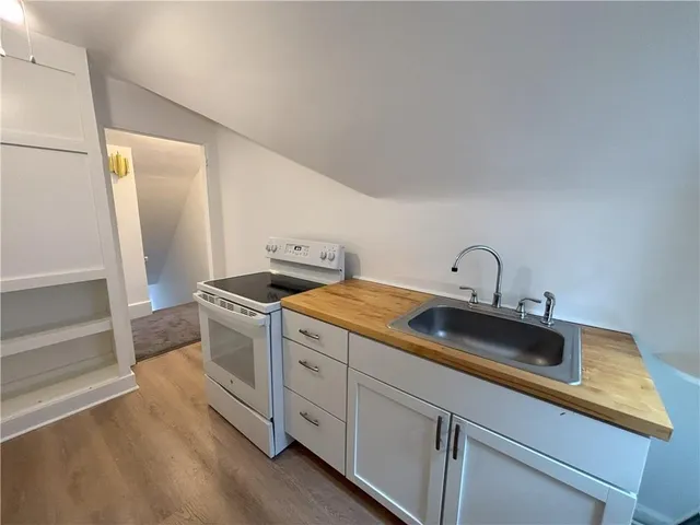 a kitchen with sink stove and cabinets