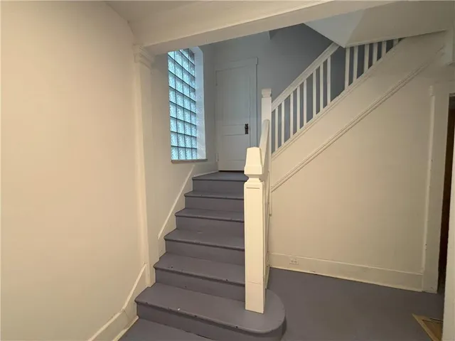 a view of staircase with wooden floor and white walls