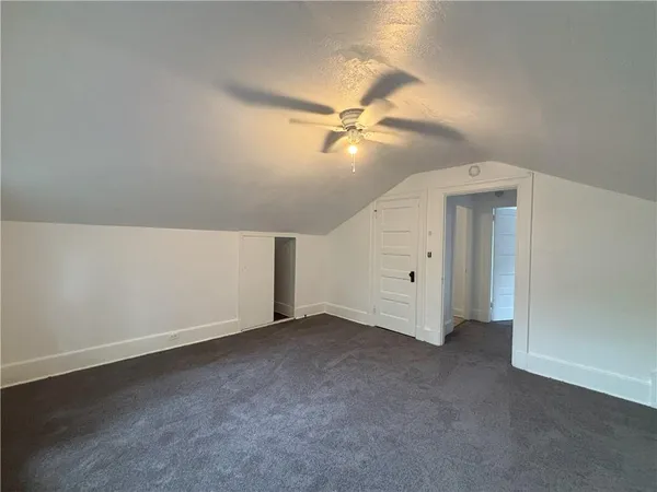 an empty room with a ceiling fan and a fan
