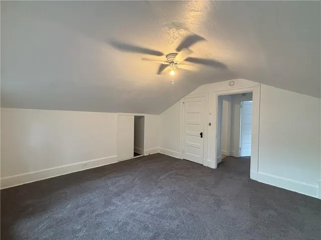 an empty room with a ceiling fan and a fan