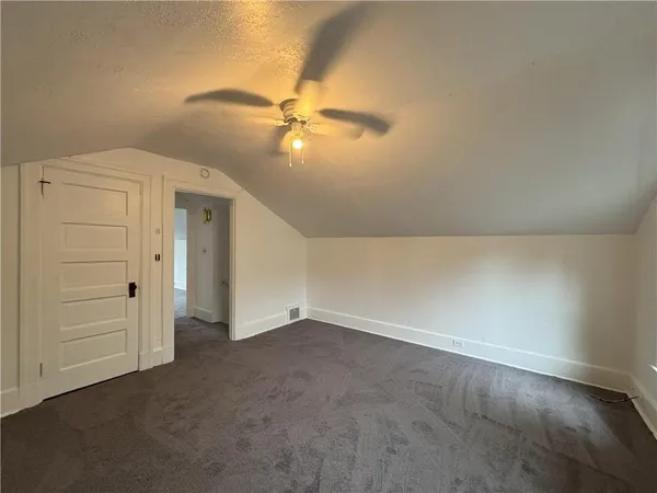 an empty room with closet and fan