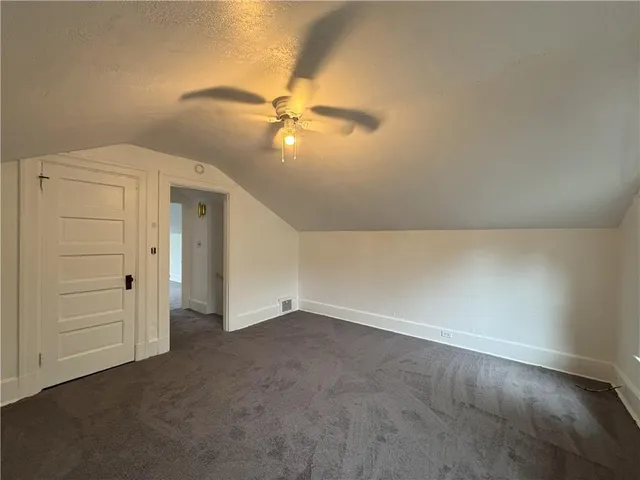 an empty room with closet and fan