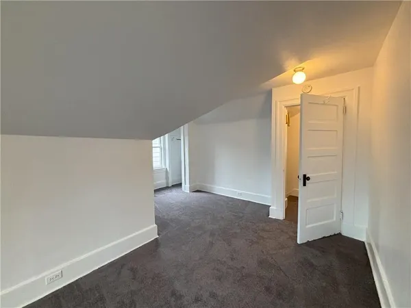 an empty room with windows and entrance to other room
