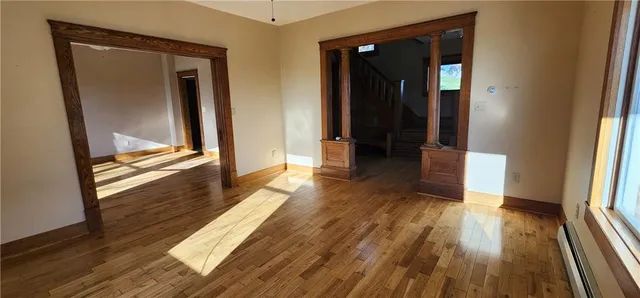 a view of a hallway with wooden floor and closet