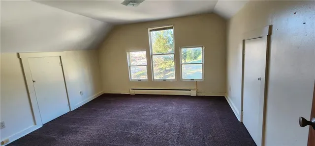 an empty room with windows and closet