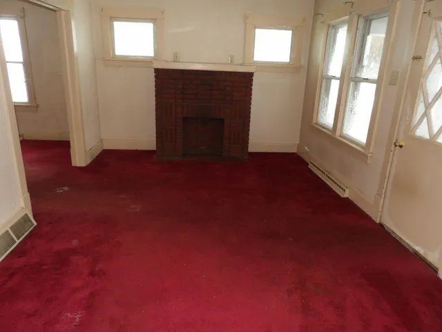 a view of empty room with a fireplace