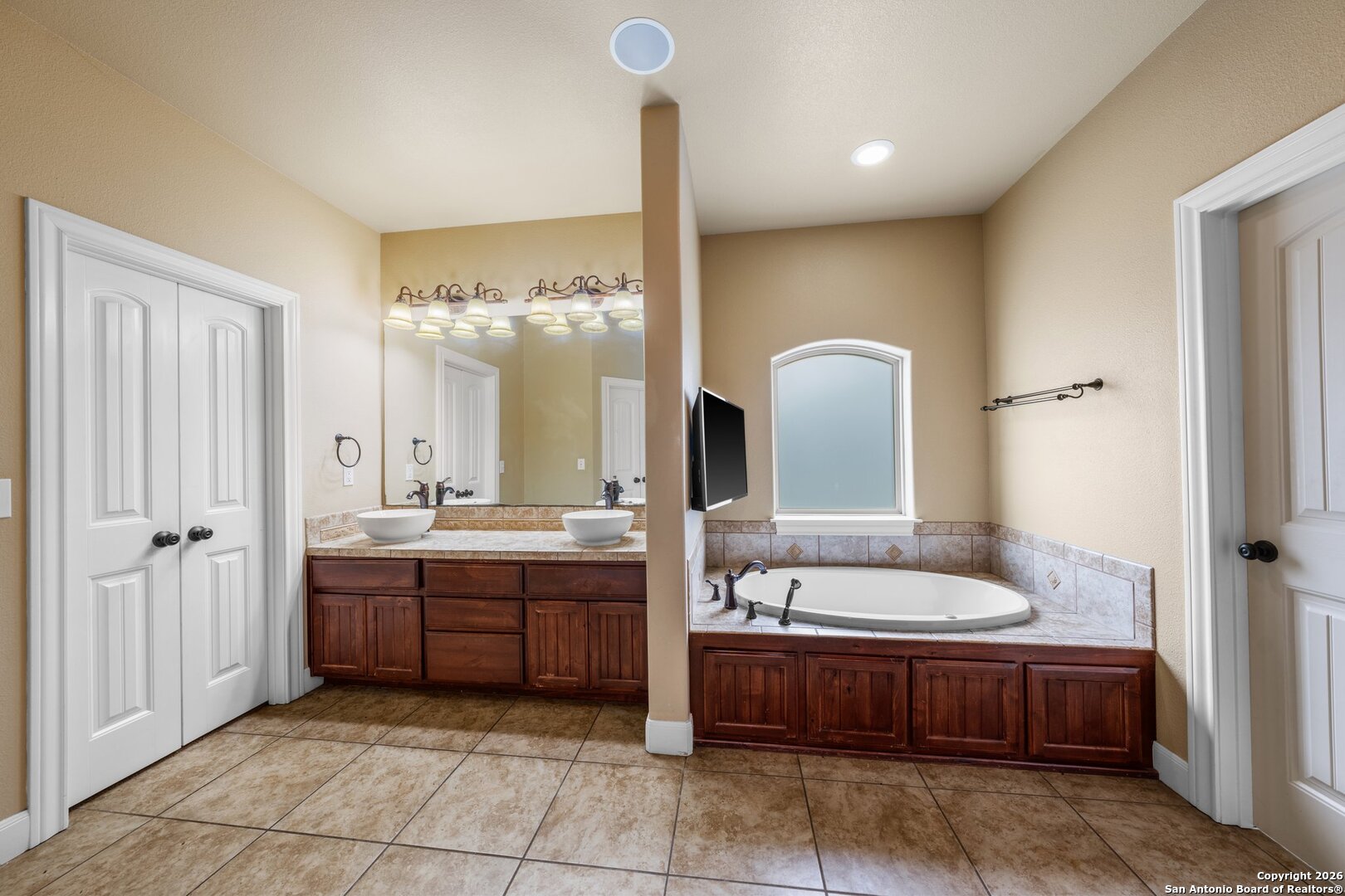 130 Rhum Road Kerrville, TX 78028 - Photo 11 of 31 a bathroom with a tub a double vanity sink and a mirror