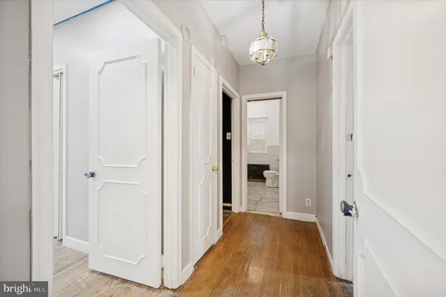 a view of a hallway with wooden floor and chandelier
