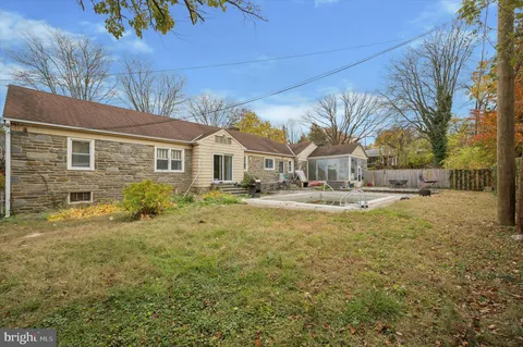 a house view with swimming pool in front of it