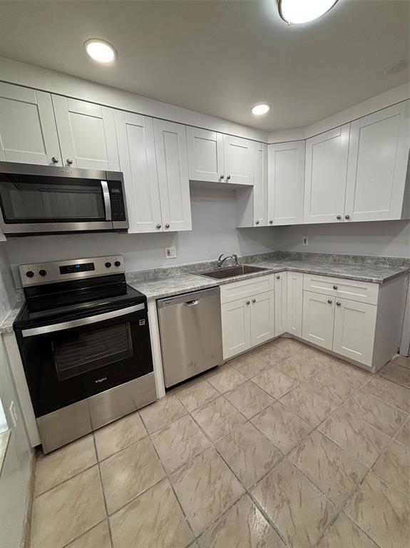 4152 Inverrary Drive, Unit 101 Lauderhill, FL 33319 - Photo 5 of 11 a kitchen with cabinets stainless steel appliances and a sink
