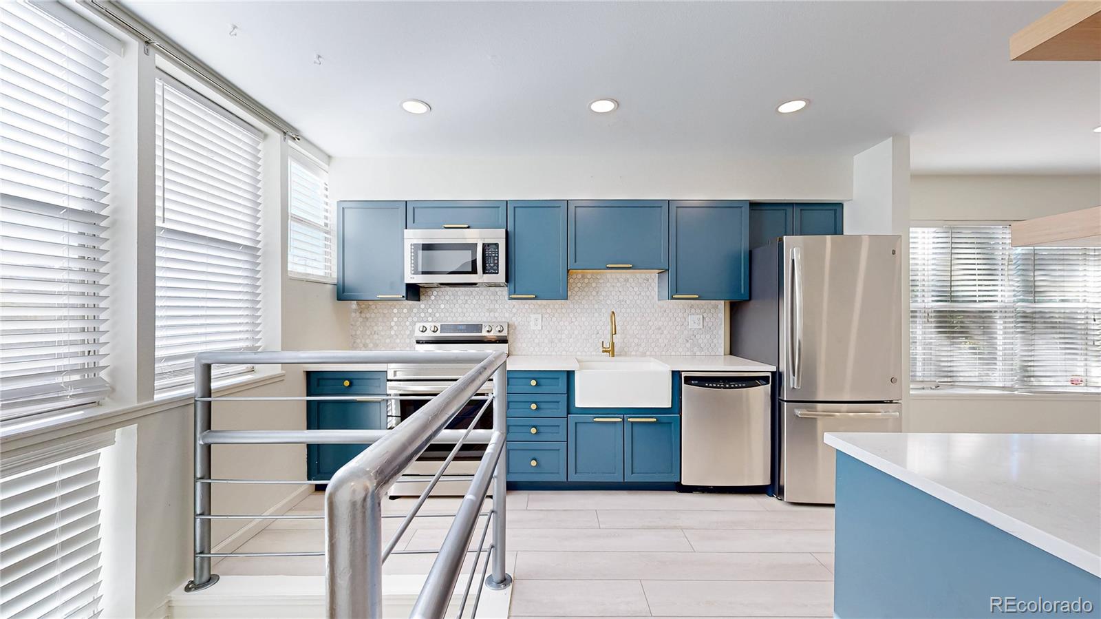 1300 Garfield Street, Unit 1A Denver, CO 80206 - Photo 3 of 33 a kitchen with stainless steel appliances kitchen island granite countertop a refrigerator stove and sink