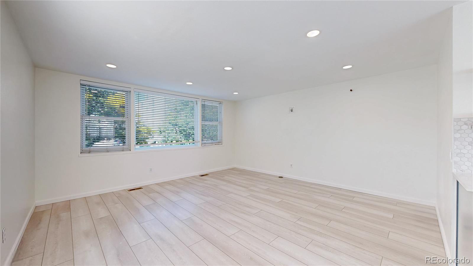 1300 Garfield Street, Unit 1A Denver, CO 80206 - Photo 9 of 33 a view of an empty room with wooden floor and a window