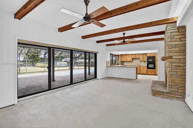 a view of an empty room with fireplace and a fan