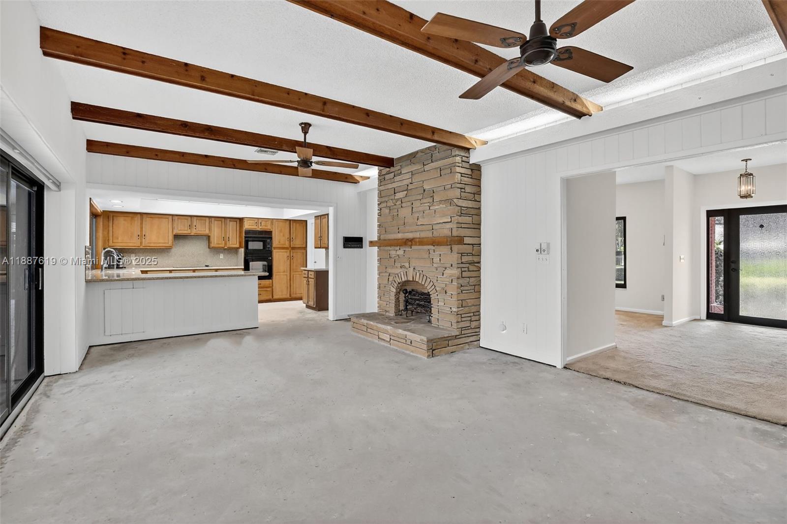 100 129th Avenue Plantation, FL 33325 - Photo 17 of 60 a view of an empty room with a fireplace and a ceiling fan