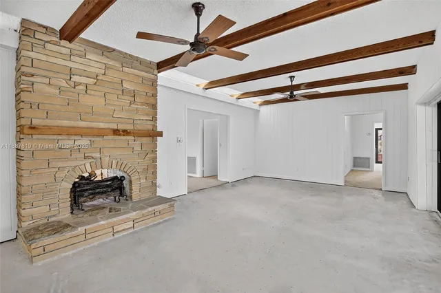 a large white kitchen with stainless steel appliances granite countertop a stove and a sink