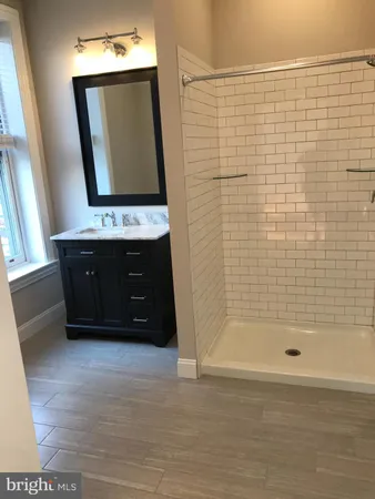 a bathroom with a bathtub a mirror and shower