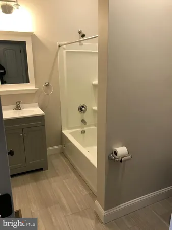 a bathroom with a tub sink and mirror
