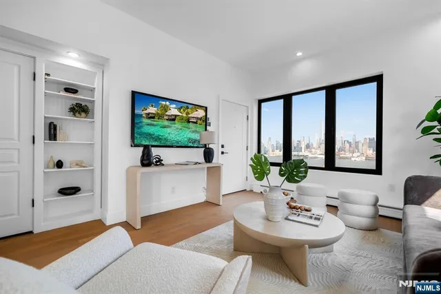 a living room with furniture a flat screen tv and a large window