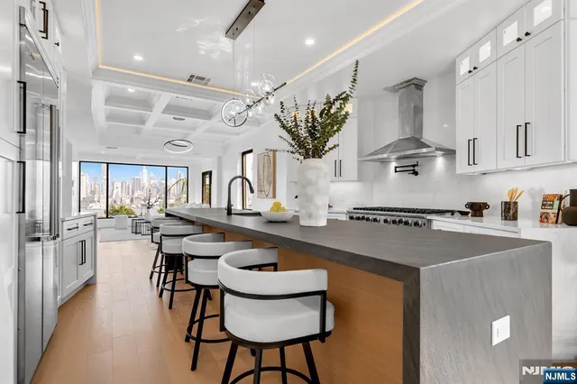 a kitchen with stainless steel appliances granite countertop a sink a stove and a refrigerator