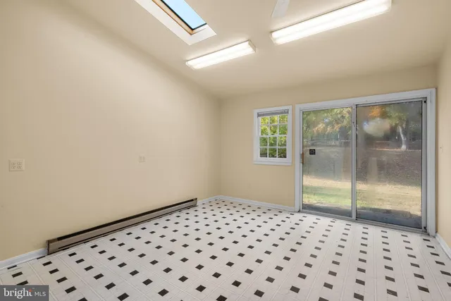 a view of a big room with wooden floor a fan and windows