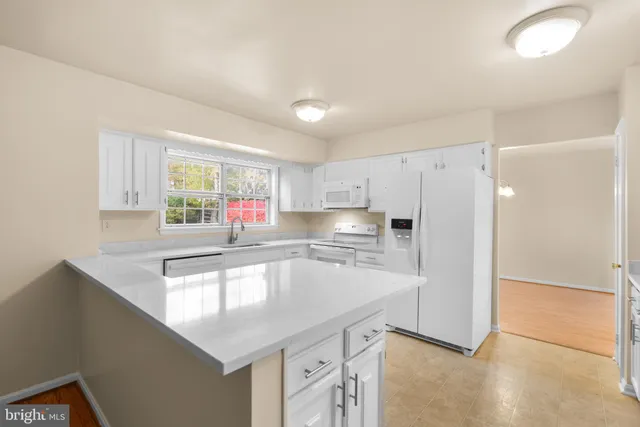 a kitchen with stainless steel appliances granite countertop a sink and a refrigerator