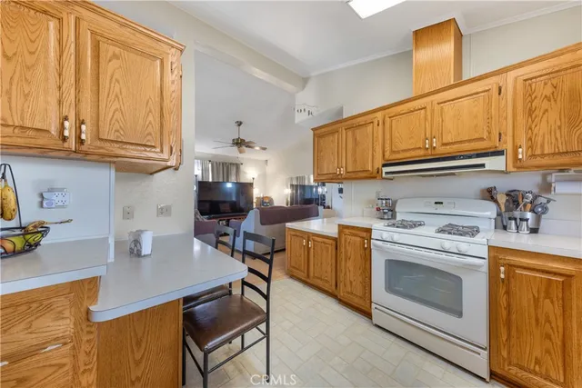 a kitchen with stainless steel appliances granite countertop a stove top oven a sink dishwasher and cabinets with wooden floor