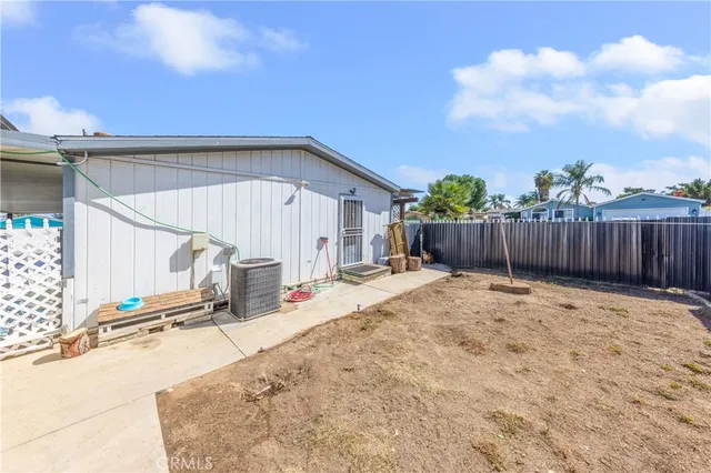 a view of a backyard with a barbeque grill and wooden fence