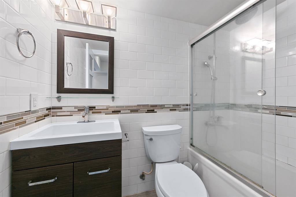 3110 Red River Street, Unit 116 Austin, TX 78705 - Photo 3 of 8 a bathroom with a toilet a sink and mirror