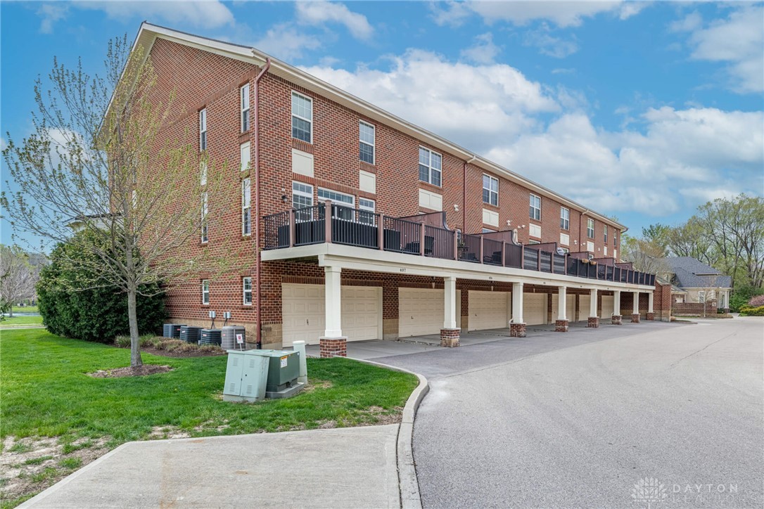407 Brownstone Row Springboro, OH 45066 - Photo 47 of 54 This multi-story townhome features a brick exterior and individual garages, perfect for modern living.