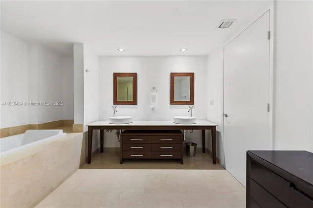 a spacious bathroom with a double vanity sink a bathtub and a double vanity