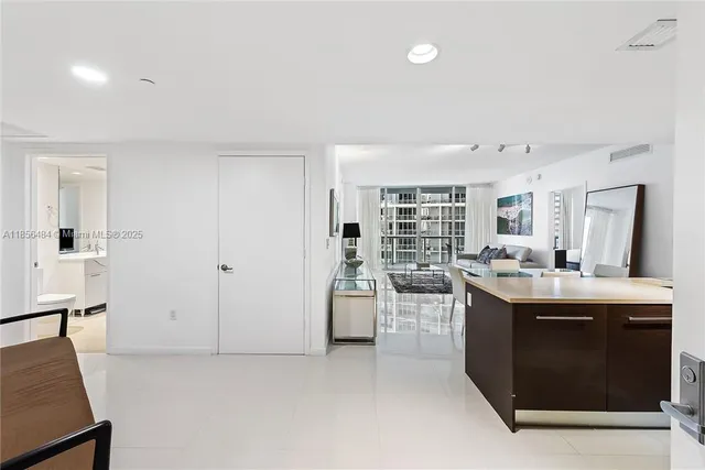 a view of living room kitchen with stainless steel appliances granite countertop cabinets and couch