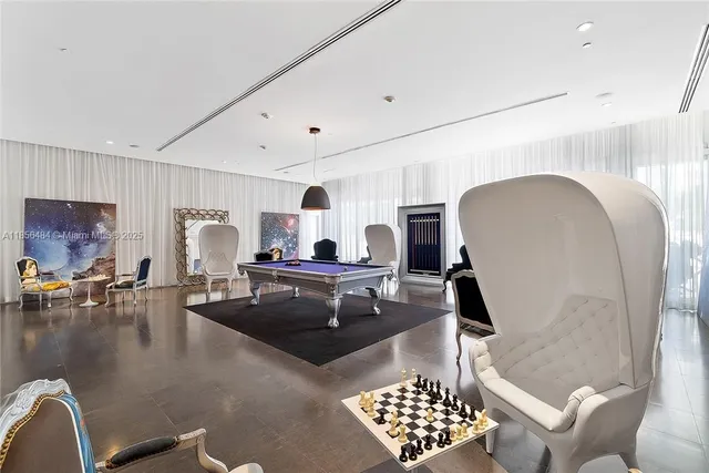 a living room with furniture a table and kitchen view