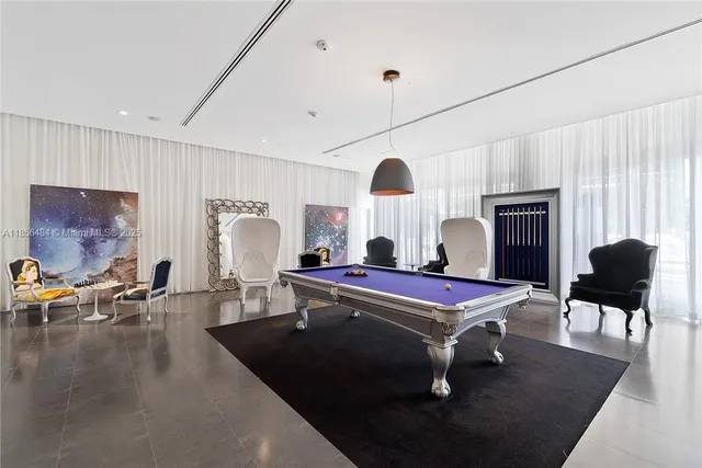 a room with furniture pool table and a window