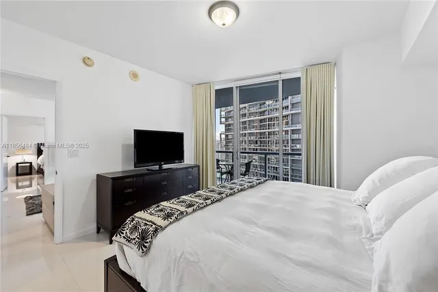 a bedroom with a bed and a flat screen tv