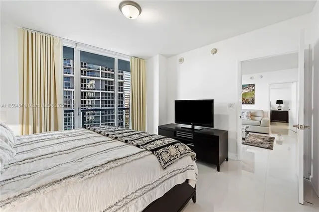 a bedroom with a bed and flat screen tv