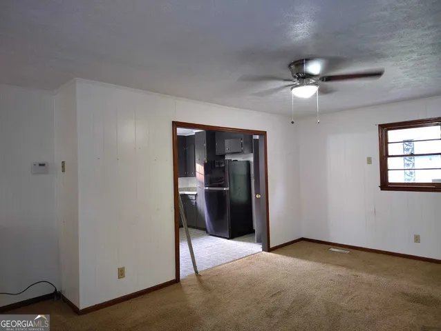 a view of a livingroom with a ceiling fan and window